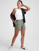 green shorts with an elastic waistband,  front zipper, button, and belt loops.